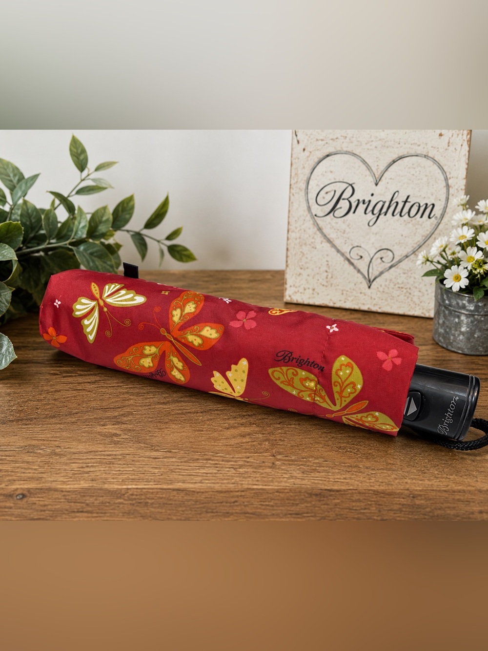 Brighton brand travel umbrella featuring a red and gold butterfly pattern.